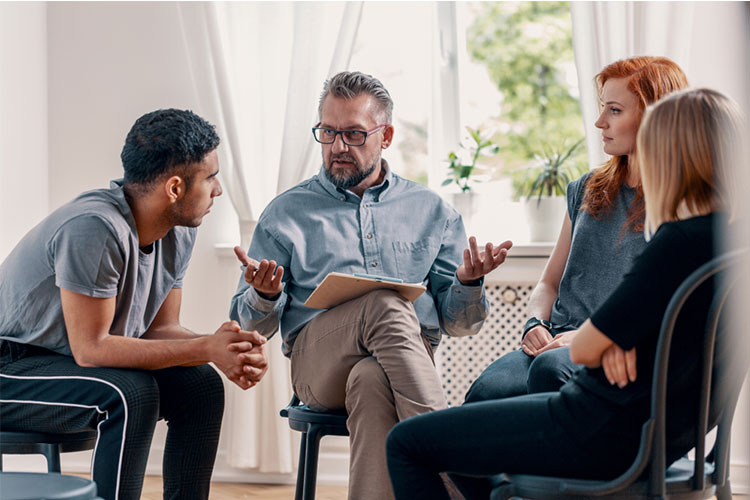 counselor talking to a group of teens