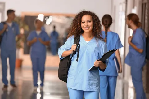 A nurse educator stands in a hallway